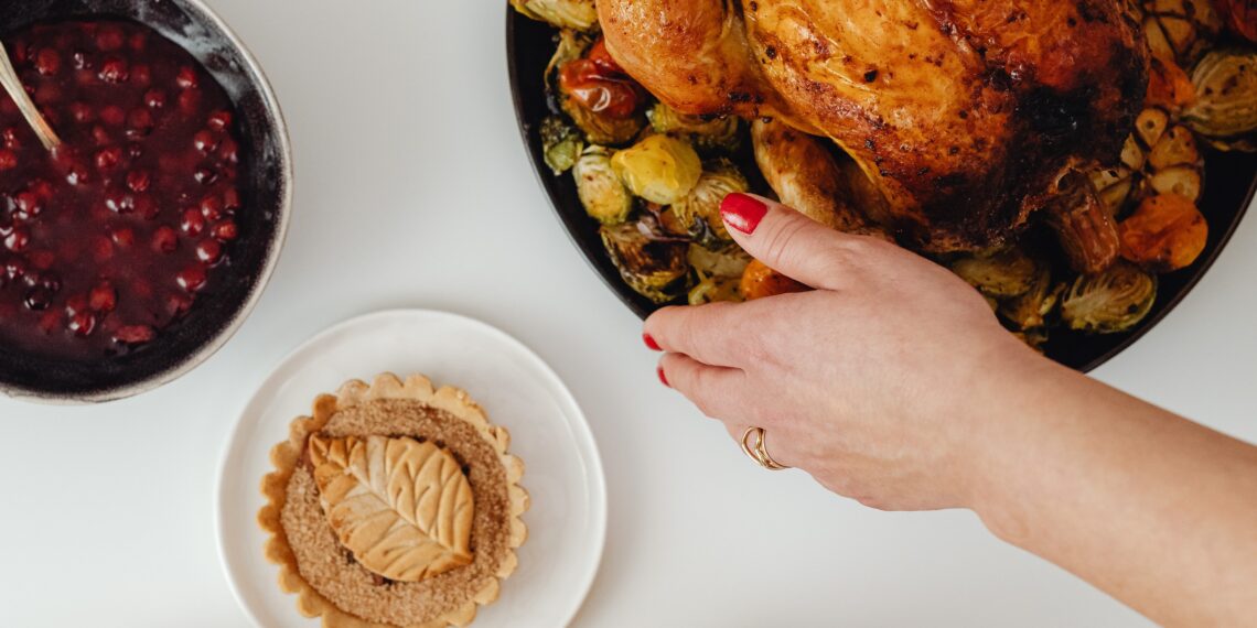 A woman serving Thanksgiving turkey on the dinner table
