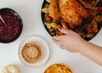 A woman serving Thanksgiving turkey on the dinner table