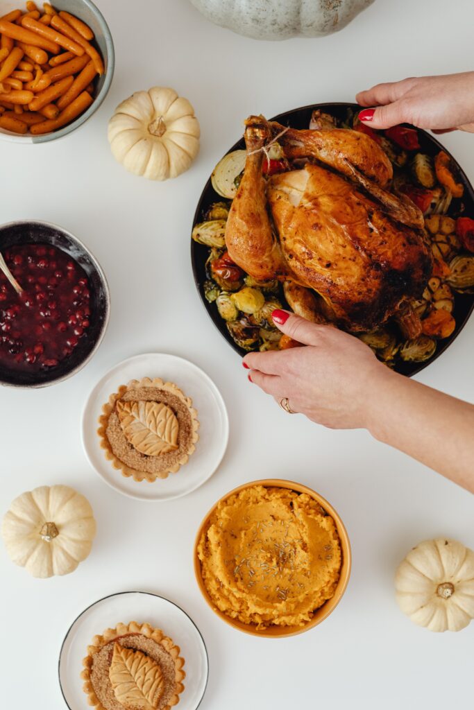 A woman serving Thanksgiving turkey on the dinner table