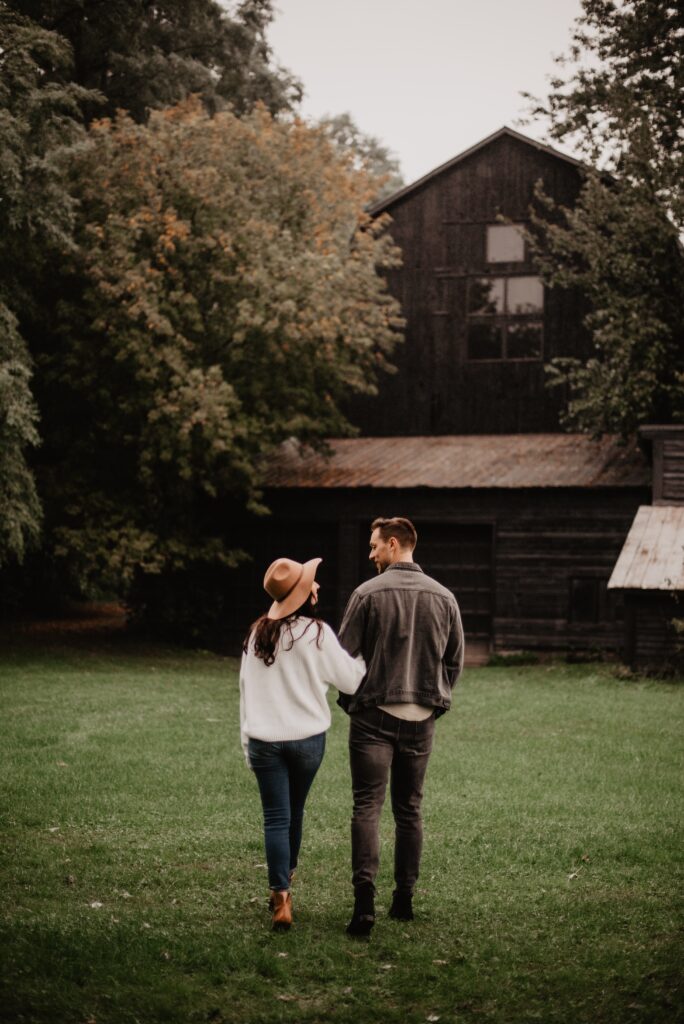 A man and a woman going for a walk outdoors towards a cabin in the woods