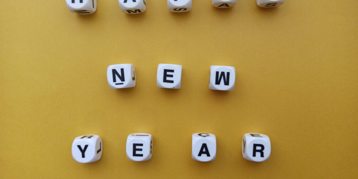 “Happy New Year” spelt with dices on yellow background
