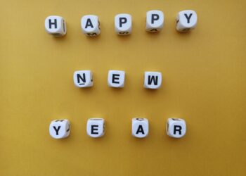 “Happy New Year” spelt with dices on yellow background