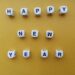 “Happy New Year” spelt with dices on yellow background