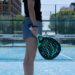 A woman holding a Padel tennis racquet on a tennis court
