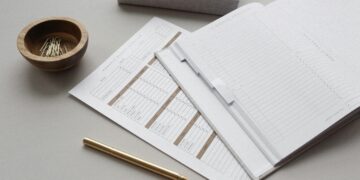 A blank finance tracker and monthly budget overview on a table.