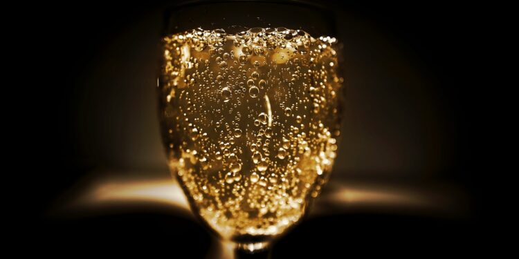 A-glass-of-golden-bubbly-sparkling-champagne-against-a-dimly-lit-background