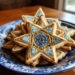 Decorative-Star-of-David-cookies-with-intricate-blue-and-gold-designs-displayed-on-a-patterned-plate-celebrating-Jewish-traditions-and-holidays-with-festive-treats.