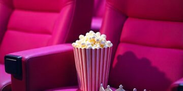 pink-cinema-seats-with-popcorn-cartridge-and-queen's-silver-crown-on-one-of-the-seats