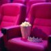 pink-cinema-seats-with-popcorn-cartridge-and-queen's-silver-crown-on-one-of-the-seats